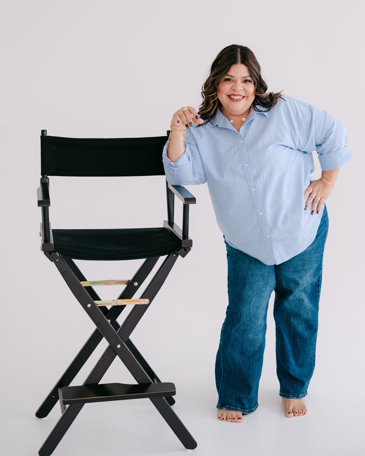 Melanie smiling, leaning on a director's chair